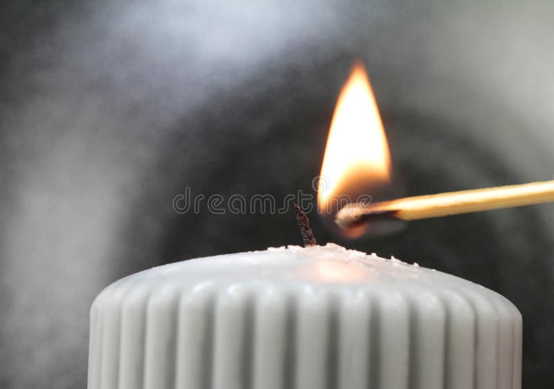 Light the wick of a candle with a match royalty free stock images