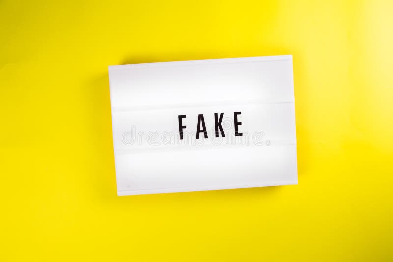 Lightbox with text FAKE isolated on yellow background, fake emotions, person