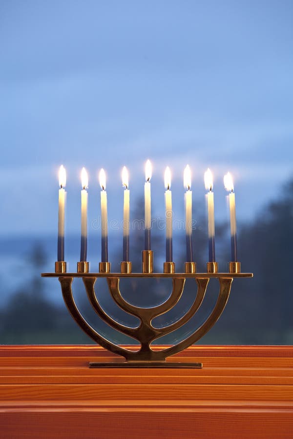 Lighted candles burning in traditional Jewish menorah for Jewish Hanukkah chanukkiah holiday with blue background stock photography Lighted candles burning in traditional Jewish menorah for Jewish Hanukkah chanukkiah holiday with blue background stock photography