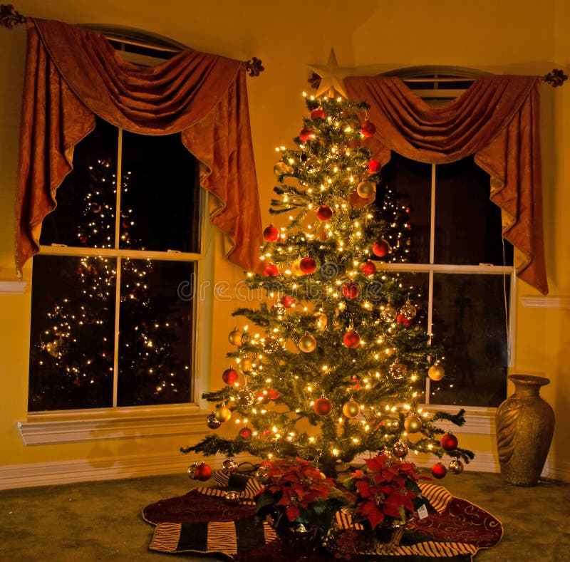 Albero di natale illuminato in accogliente casa, albero riflette in windows.