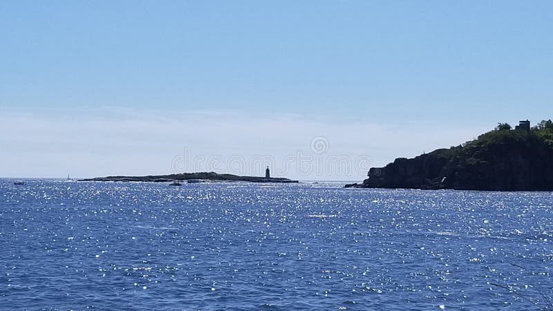 A lighthouse far off in the distance in maine