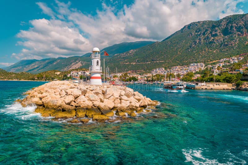 Lighthouse on a sunny morning with fishing boats at the harbor of Kas Turkey