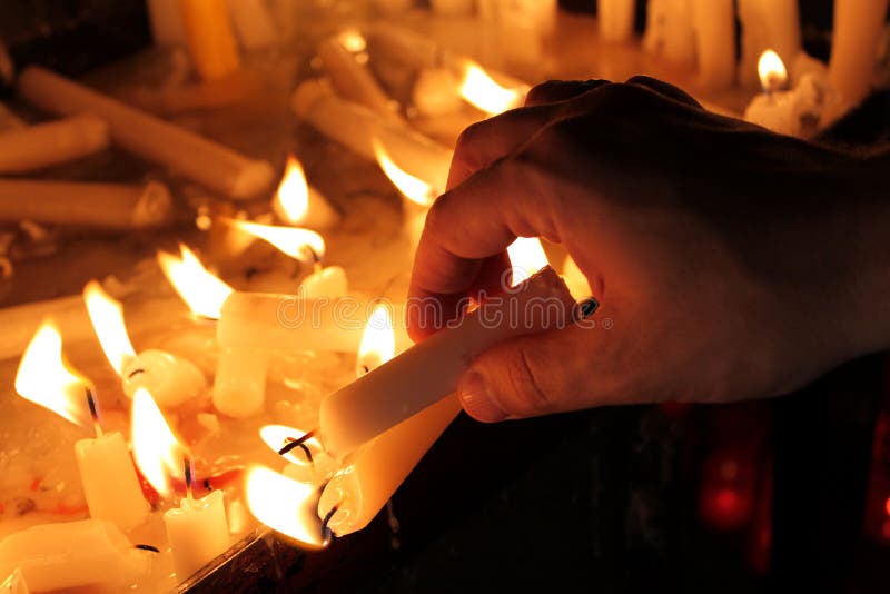 Lighting a Candle stock image. Image of catholic, black 127476201