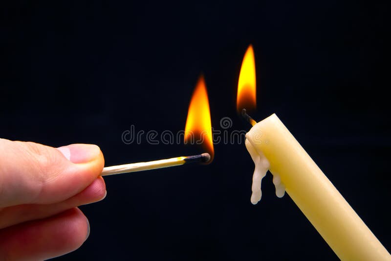 Lighting a Candle with a Wooden Match on a Dark Background. Burning