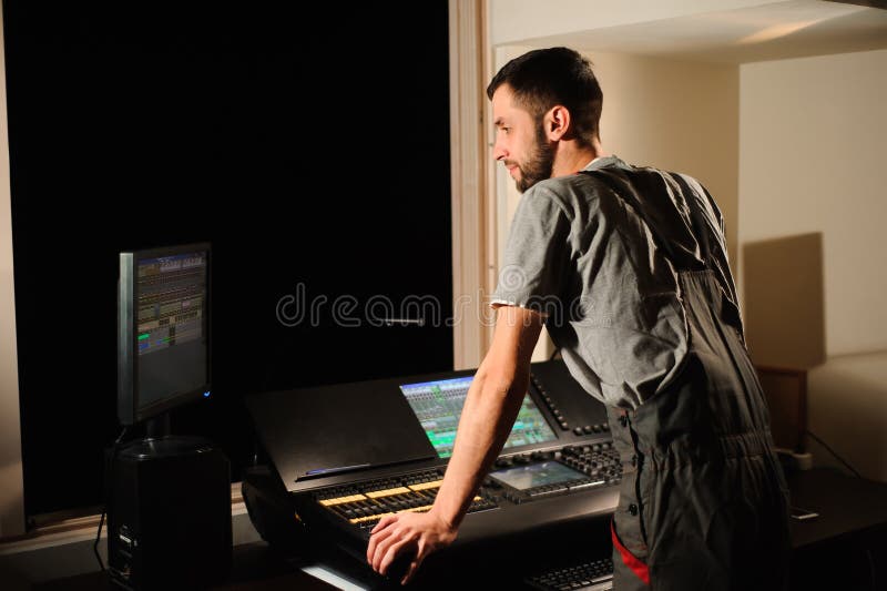 A Lighting Engineer Works with Lights Technicians Control on the