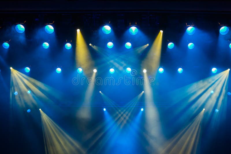 Lighting equipment on the stage of the theatre during the performance. The light rays from the spotlight through the smoke