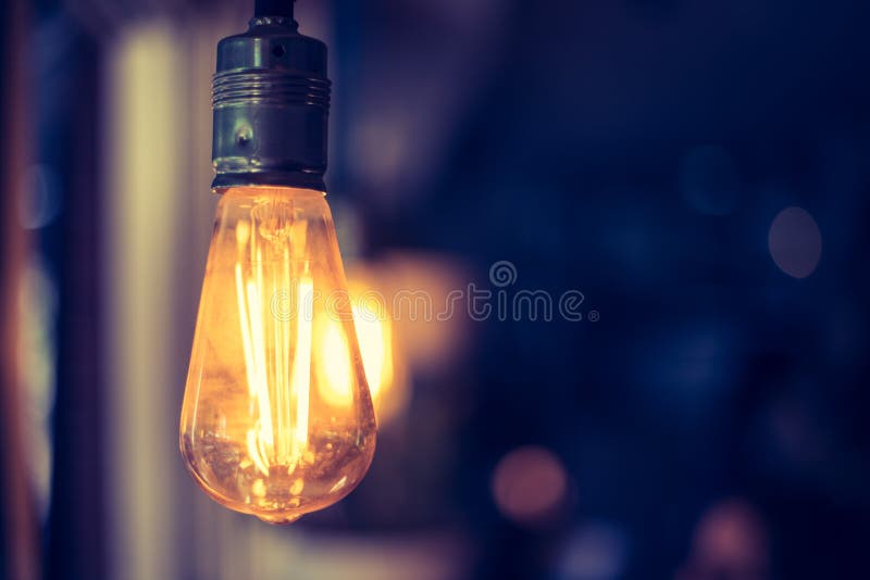 Lightning in the restaurant: Close up of a hanging, orange lightbulb royalty free stock photography