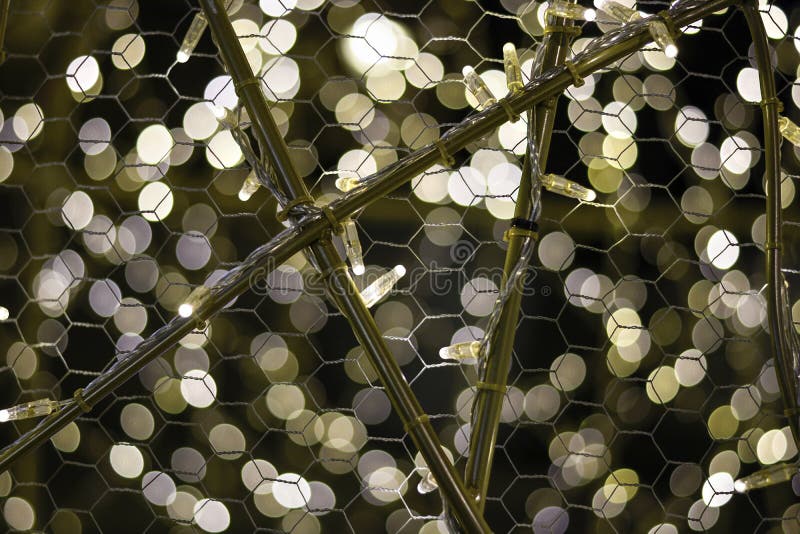 Lights Attached To an Iron Wire Fence. Bokeh Lights in Background Stock