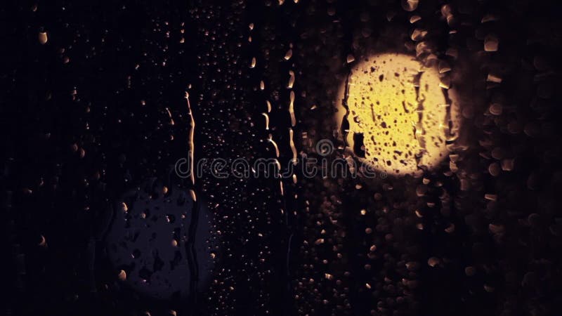 The lights of the night city. Misted glass. Liquid raindrops on the window. Sadness and sad mood background.