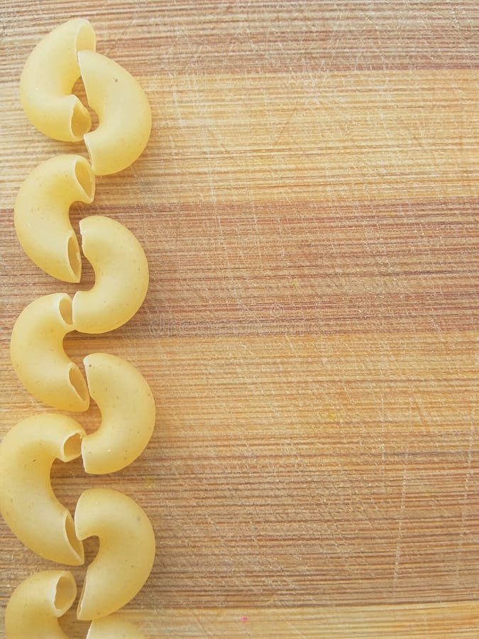Ligne de pâtes de macaronis sur le fond en bois
