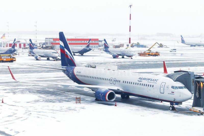 Moscow, Russia - December 2, 2018: Aeroflot Russian Airlines Boeing 737 is boarded in the Sheremetyevo International Airport during a heavy snowfall. Moscow, Russia - December 2, 2018: Aeroflot Russian Airlines Boeing 737 is boarded in the Sheremetyevo International Airport during a heavy snowfall