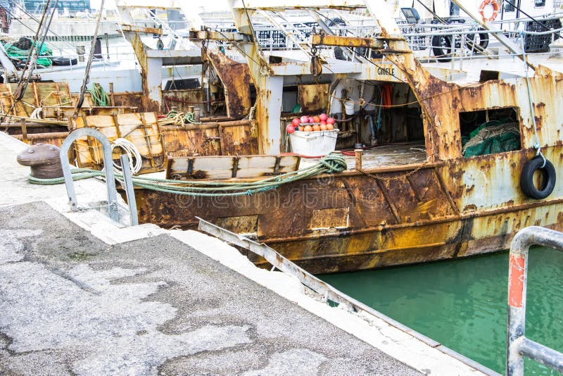 Liguria Italy - Old trawler fishing boats with fishing equipment docked in port