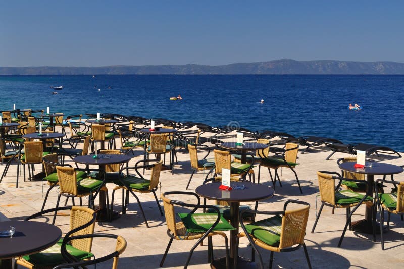 Lijsten en stoelen van restaurant in strand van Podgora stock fotografie Lijsten en stoelen van restaurant in strand van Podgora stock fotografie