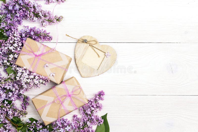 Lilac bloemen met giftdozen en hartkader op witte houten achtergrond stock afbeeldingen Lilac bloemen met giftdozen en hartkader op witte houten achtergrond stock afbeeldingen