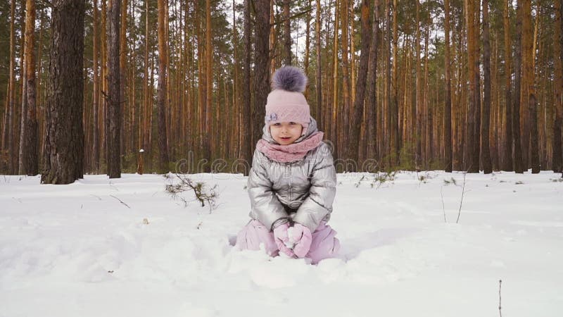 Lilla flickan kastar upp en snö som är slowmotion