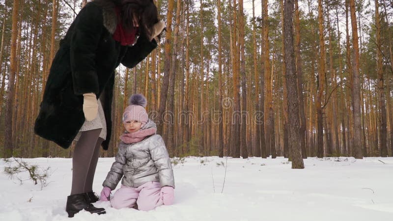 Lilla flickan lägger på snö som är slowmotion