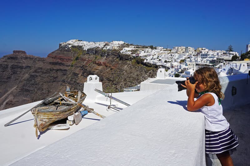 lilla flickan tar bilder av härliga sikter av Santorini royaltyfri fotografi lilla flickan tar bilder av härliga sikter av Santorini royaltyfri fotografi