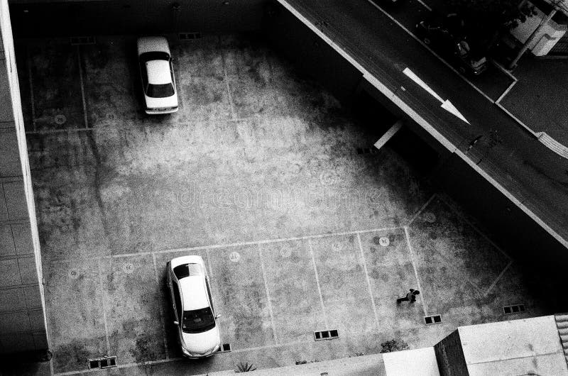 Lima two cars in a parking seen from above. Parking seen from above with two cars parked and a person walking by. Lima, Argentic High quality Scan Nikon FM2 stock image Lima two cars in a parking seen from above. Parking seen from above with two cars parked and a person walking by. Lima, Argentic High quality Scan Nikon FM2 stock image