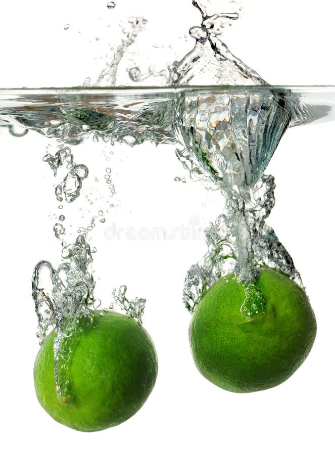 Limes splashing into Water stock photo. Image of beverage 25563276