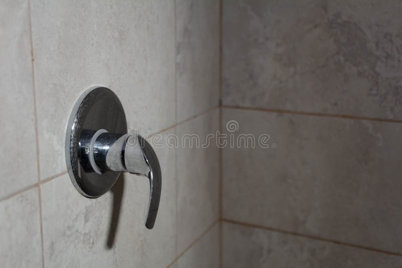 Limescale deposits on the water control handle in the shower. Selective focus, shallow depth of field royalty free stock photos