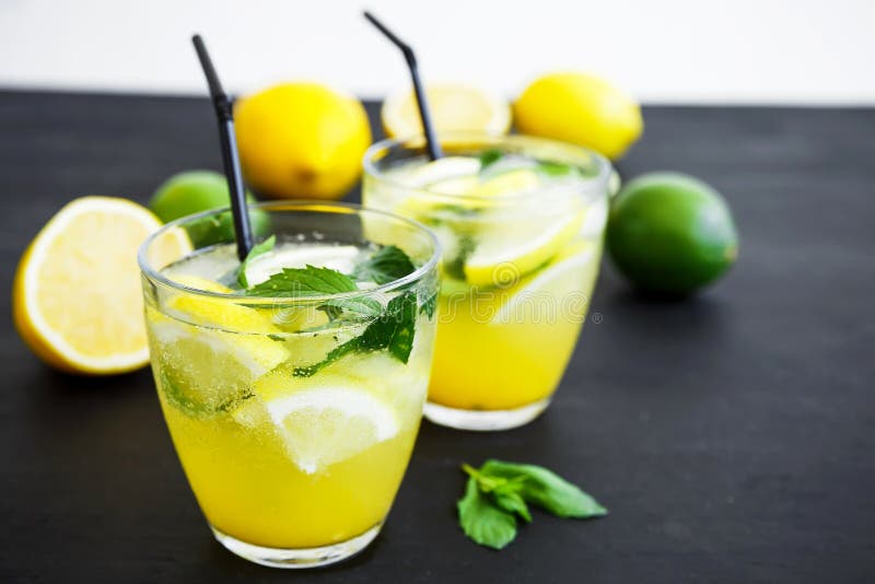 Limonada de refrescamento no vidro com cais, limões e hortelã Bebidas do verão foto de stock Limonada de refrescamento no vidro com cais, limões e hortelã Bebidas do verão foto de stock