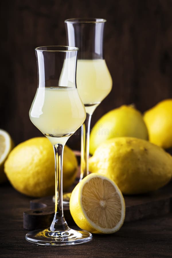 Limoncello, sweet Italian lemon liqueur, traditional strong alcoholic drink. Still life in vintage style, selective focus