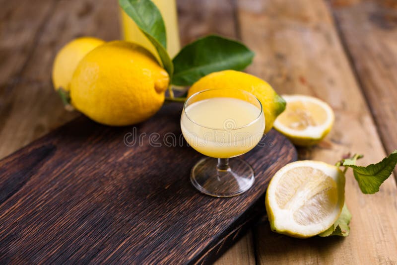 Limoncello и лимоны на деревянной доске Традиционный алкоголь стоковое изображение rf Limoncello и лимоны на деревянной доске Традиционный алкоголь стоковое изображение rf