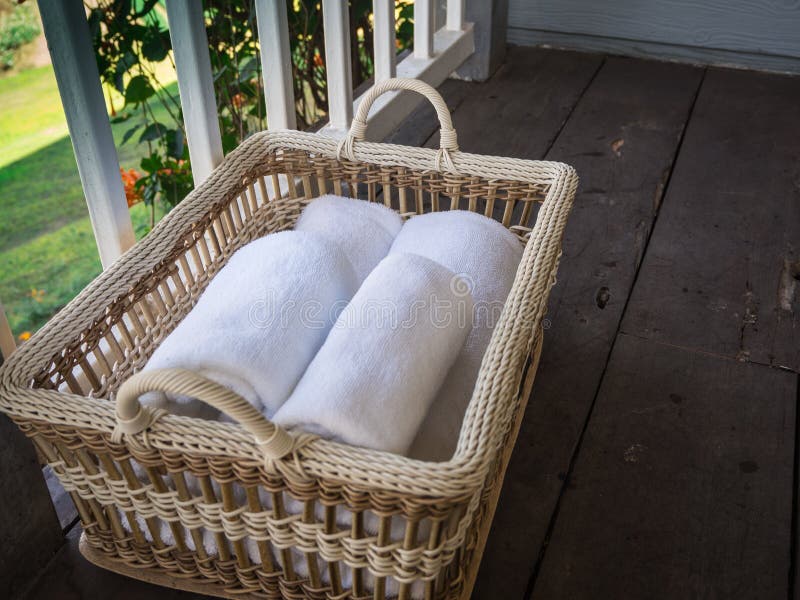Limpe as toalhas brancas em uma cesta em um de madeira e em um balcão imagem de stock Limpe as toalhas brancas em uma cesta em um de madeira e em um balcão imagem de stock