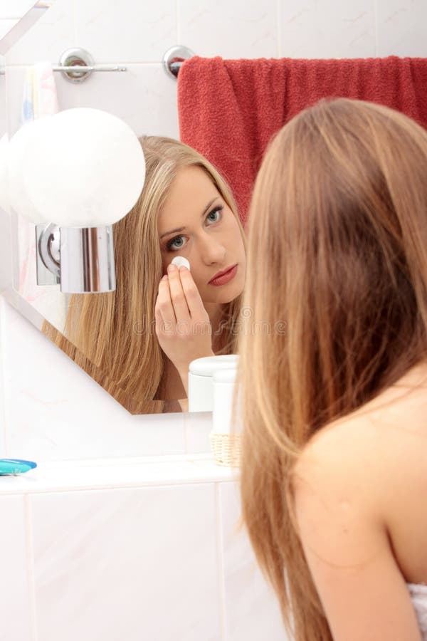 A Menina Bonita Olha Em Um Espelho Em Um Banheiro Foto de Stock - Imagem de  cara, adulto: 13967092