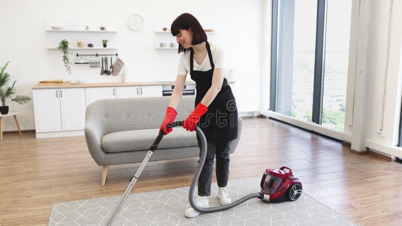 Limpiadora profesional femenina en apron limpia activamente apartamento moderno. almacen de video