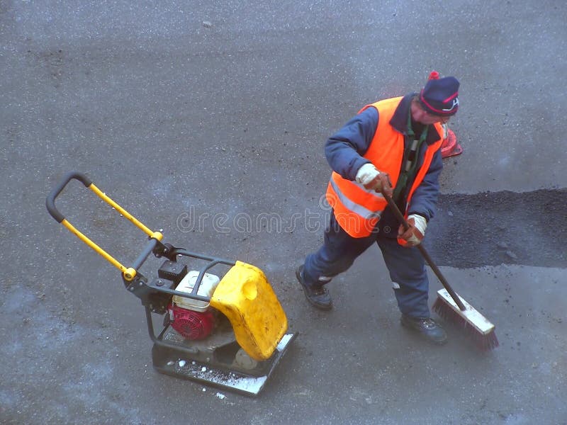 Road mender at work; hard work, power, blue-collar concept. Road mender at work; hard work, power, blue-collar concept