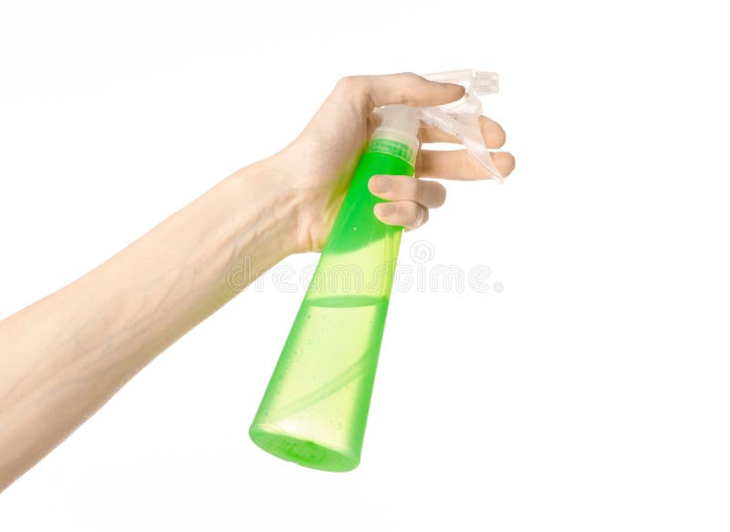 Limpieza del tema de la casa y del limpiador: la mano del hombre que sostiene una botella verde del espray para limpiar aislada e imagenes de archivo Limpieza del tema de la casa y del limpiador: la mano del hombre que sostiene una botella verde del espray para limpiar aislada e imagenes de archivo