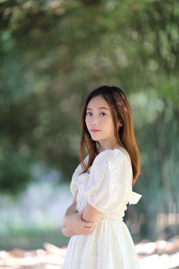 Linda jovem com vestido branco no fundo da floresta de bambu foto de stock