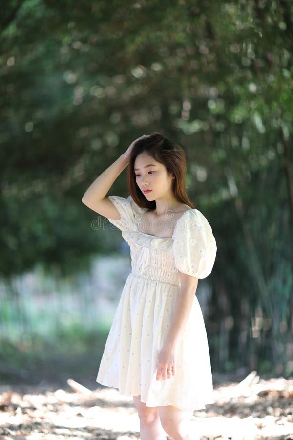 Linda jovem com vestido branco no fundo da floresta de bambu imagem de stock royalty free