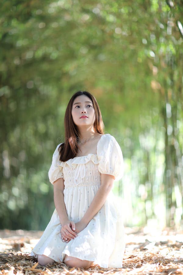 Linda jovem com vestido branco no fundo da floresta de bambu imagens de stock