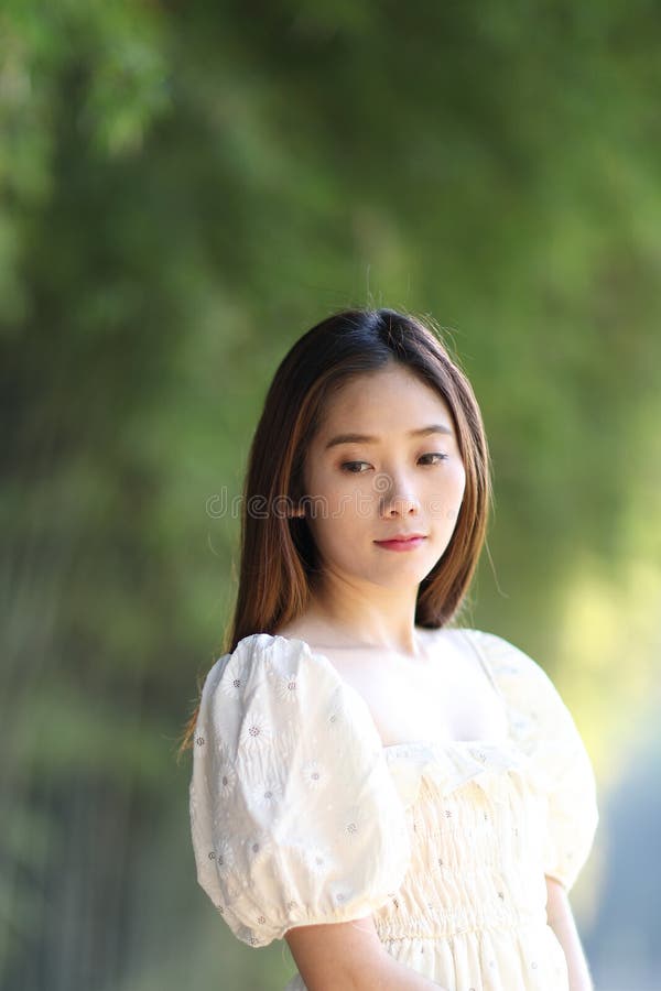 Linda jovem com vestido branco no fundo da floresta de bambu imagens de stock
