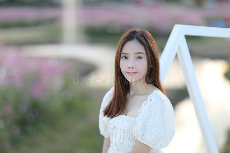 Linda jovem com vestido branco no fundo do jardim imagens de stock royalty free