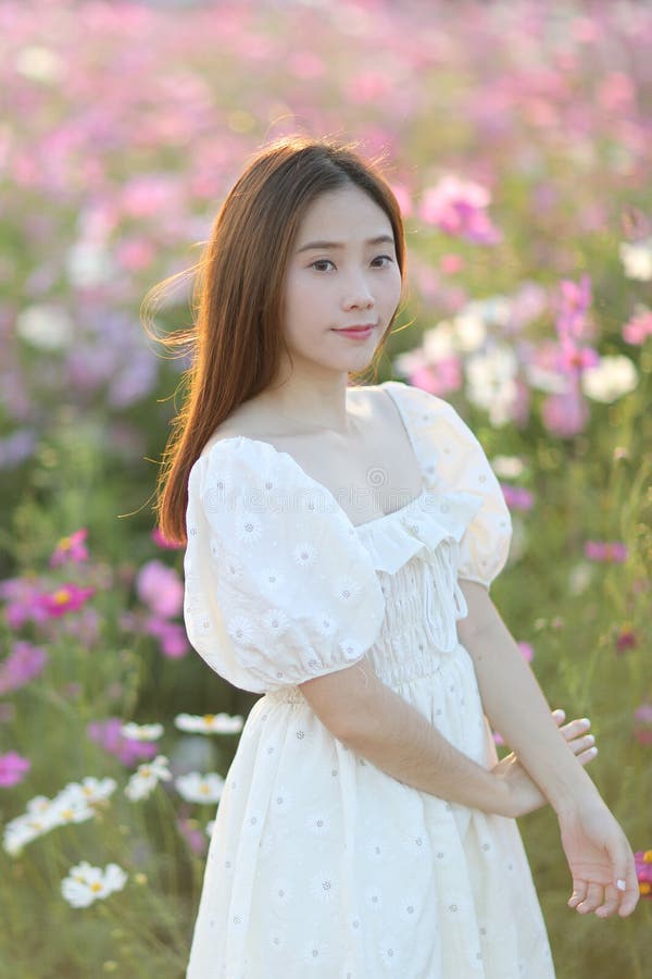 Linda jovem com vestido branco no fundo do jardim imagens de stock royalty free