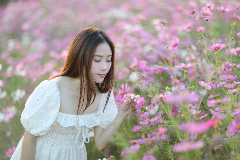 Linda jovem com vestido branco no fundo do jardim imagem de stock