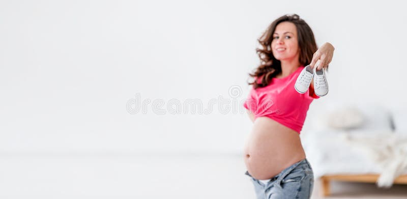 Linda Mujer Joven Embarazada Con Ropa Moderna Habitación Blanca. De Maternidad Y Embarazo Foto de archivo - de casero, bandera: 245032896