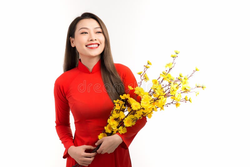 Linda mulher asiática usando o Vietnã tradicional Ao dai segurando flor de pêssego nos feriados de Tet imagem de stock royalty free Linda mulher asiática usando o Vietnã tradicional Ao dai segurando flor de pêssego nos feriados de Tet imagem de stock royalty free