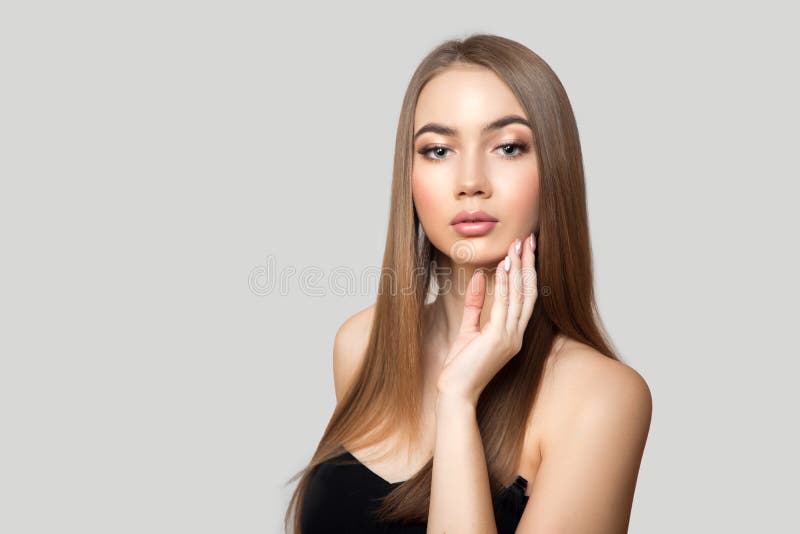 Linda mulher com cabelo liso brilhante e maquiagem Retrato sobre fundo cinza Limpar fotografia de stock Linda mulher com cabelo liso brilhante e maquiagem Retrato sobre fundo cinza Limpar fotografia de stock