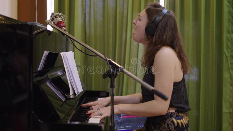 Linda mulher ocidental toca piano e canta com emoção vídeos de arquivo