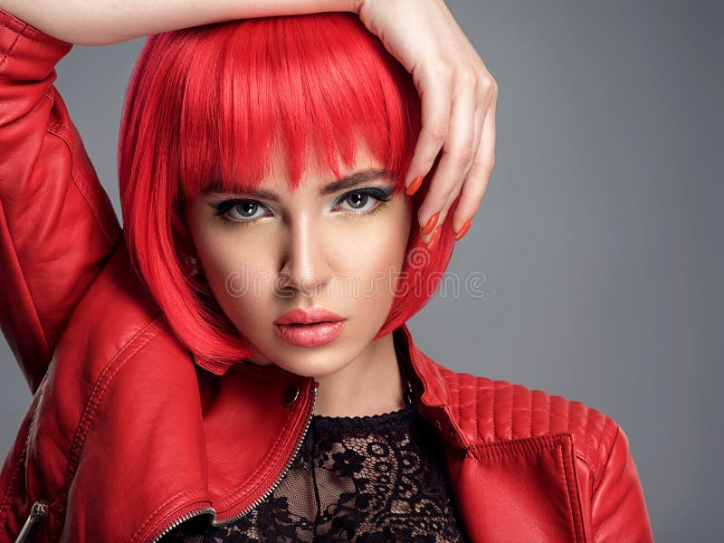 Linda mulher sexy com penteado vermelho brilhante Modelo de moda Linda menina em uma jaqueta de couro Cara espantosa de um foto de stock royalty free Linda mulher sexy com penteado vermelho brilhante Modelo de moda Linda menina em uma jaqueta de couro Cara espantosa de um foto de stock royalty free