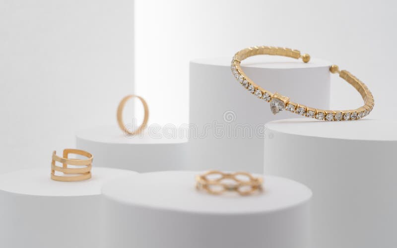 Linda pulseira preciosa com coletores de diamantes e anéis em plataformas brancas foto de stock royalty free Linda pulseira preciosa com coletores de diamantes e anéis em plataformas brancas foto de stock royalty free