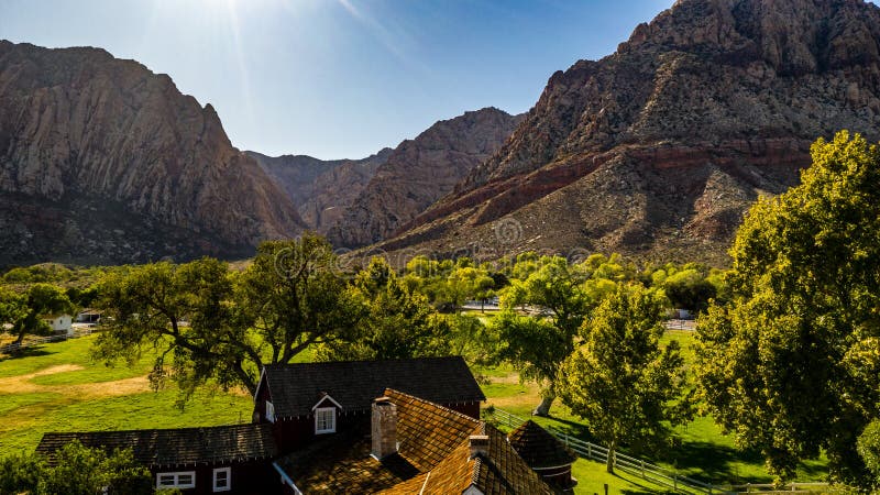 Beautiful view of famous Spring Mountain Ranch State Park near Las Vegas and Red Rock Canyon, Nevada during autumn with pink and red rock mountains, blue sky, green trees and grass, and purple hills. Beautiful view of famous Spring Mountain Ranch State Park near Las Vegas and Red Rock Canyon, Nevada during autumn with pink and red rock mountains, blue sky, green trees and grass, and purple hills