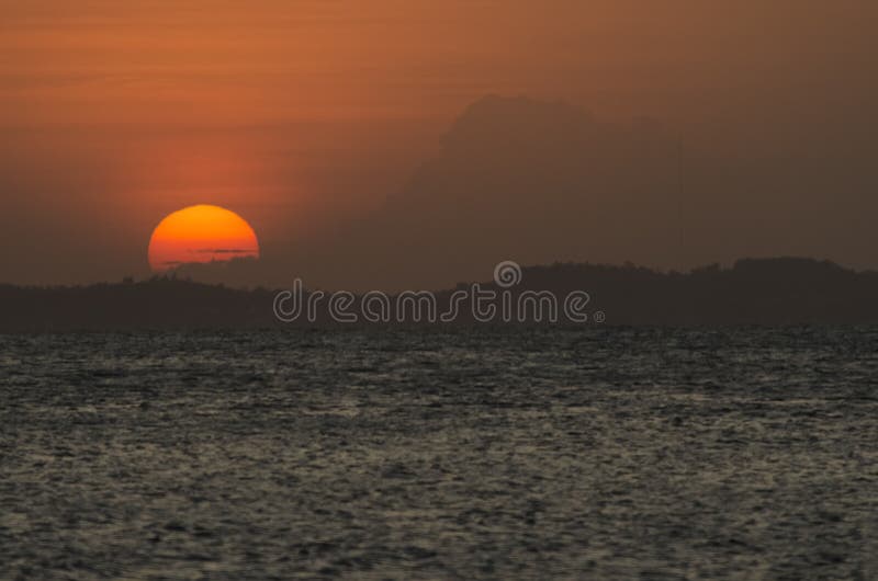 Lindo pôr do sol amarelo e laranja dramático que cai atrás das montanhas foto de stock royalty free