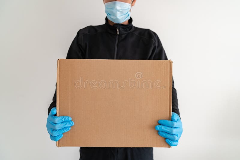 On-line-Nahrungsmittellieferer, der zu Hause das Türpappschachtelpaket trägt Schutzhandschuh- und Masken-EVP-Verhinderung bietet stockfotos
