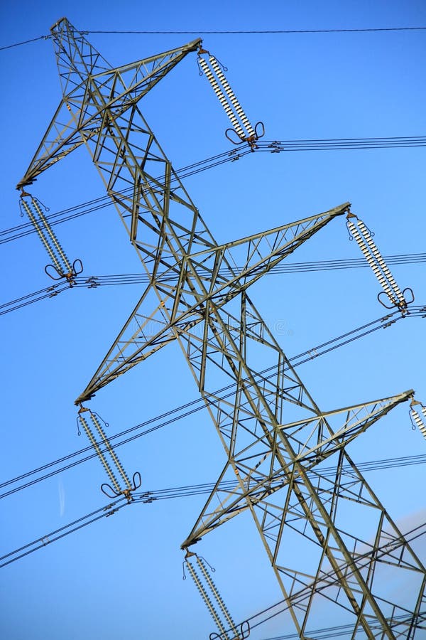A close up picture of power lines with blue sky in the background. A close up picture of power lines with blue sky in the background