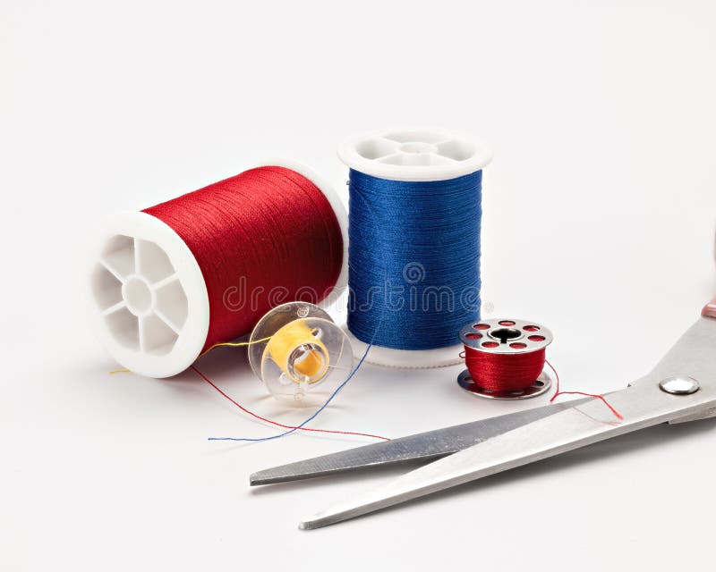 Linha de costura e um par de tesouras de cores diferentes imagem de stock Linha de costura e um par de tesouras de cores diferentes imagem de stock